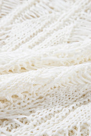 Open-knit crochet sweater in ivory with fringe detail and a cotton blend texture.