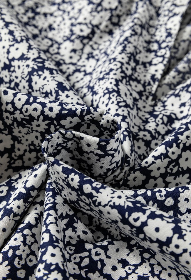 Bloomchic blouse with navy and white floral print and notched sleeves.