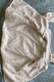 Cream teddy pea coat with smooth lining and double-breasted closure detail.
