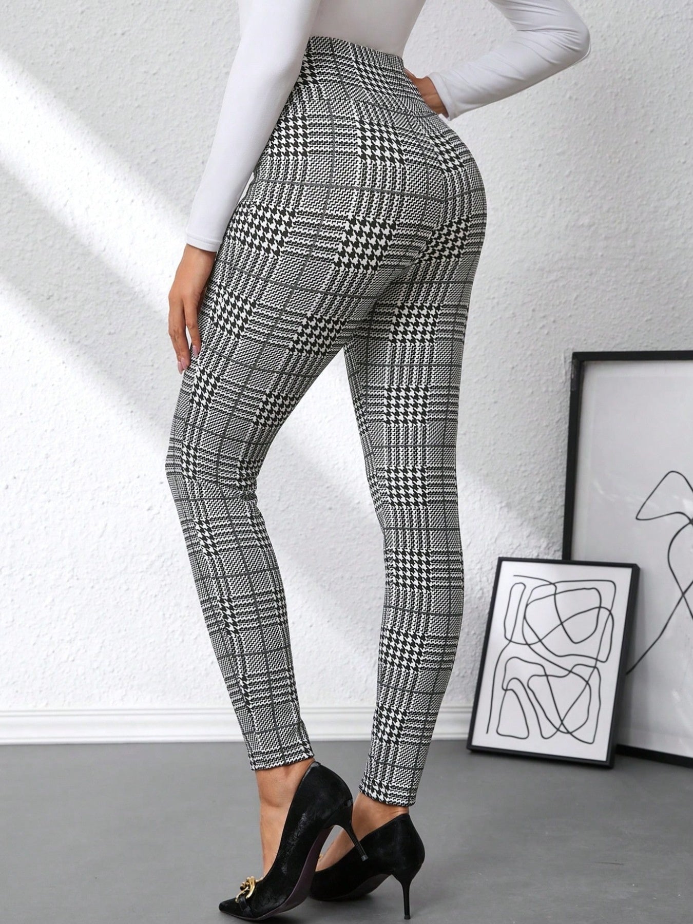 Plaid high waist slim fit ankle length pants in black and white with decorative buttons.