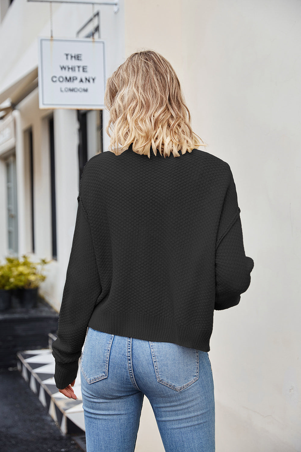 Black textured knit cropped cardigan with button detail.