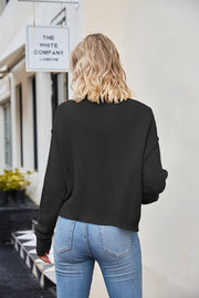 Black textured knit cropped cardigan with button detail.