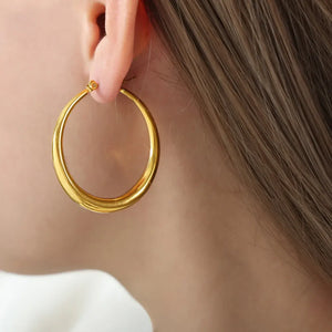 Sculpted oval gold hoop earrings with a polished finish.