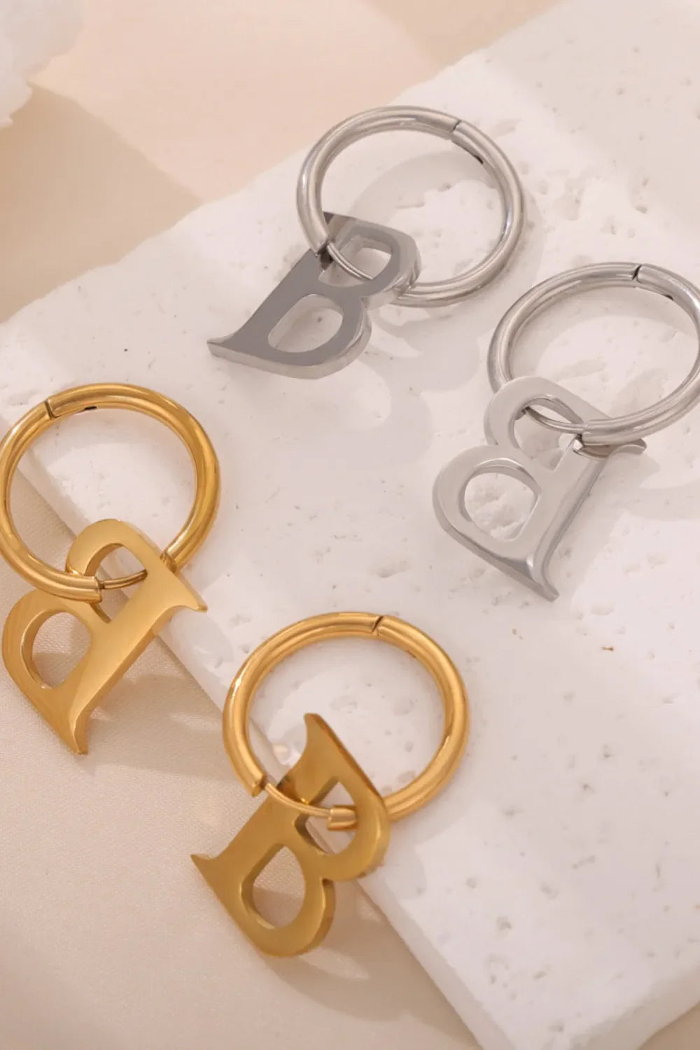 Initial letter B hoop earrings in gold and silver.