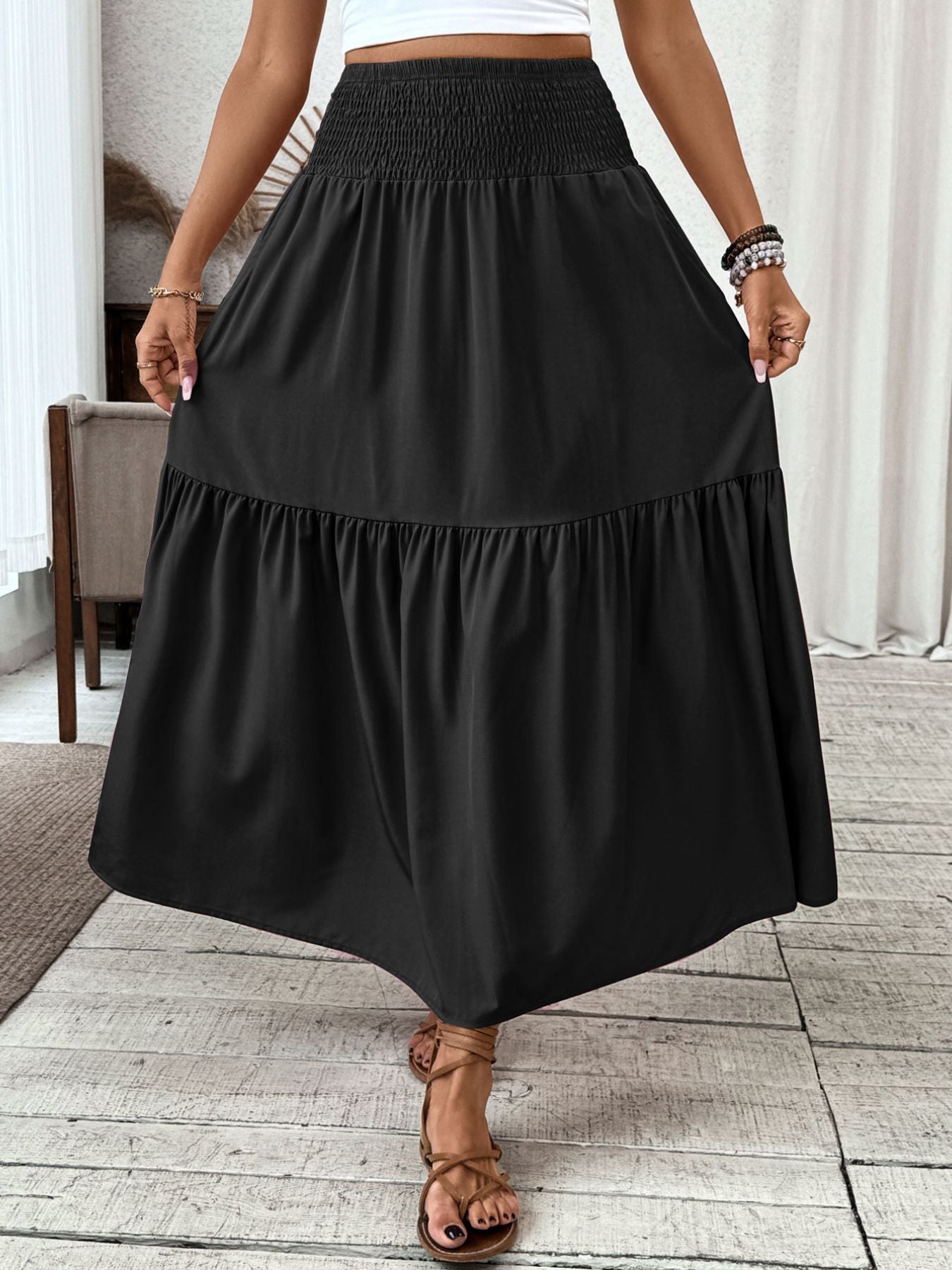 Black ruffled smocked waist maxi skirt with a tiered hem