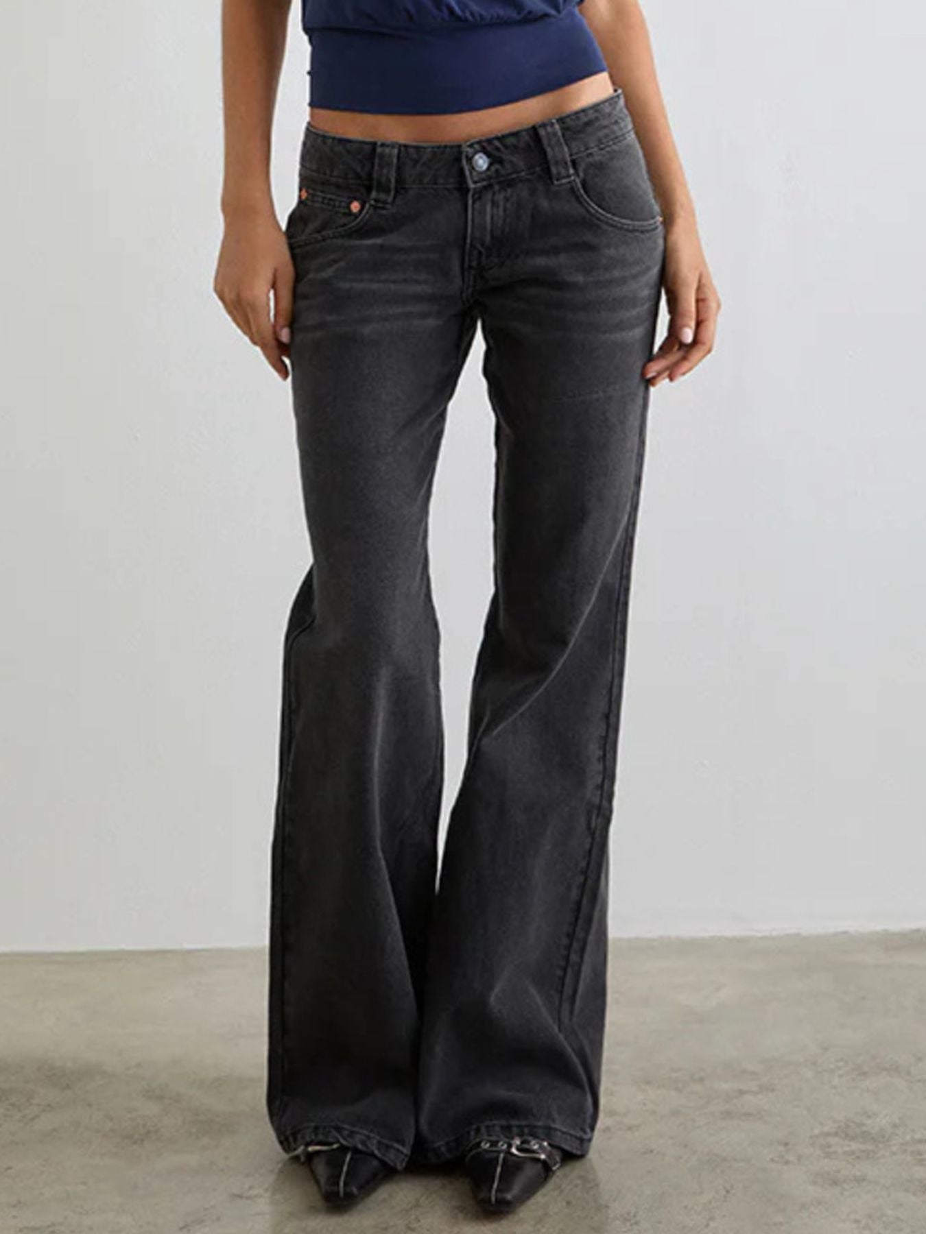 Dark gray low rise flare leg jeans with pockets and button fly.