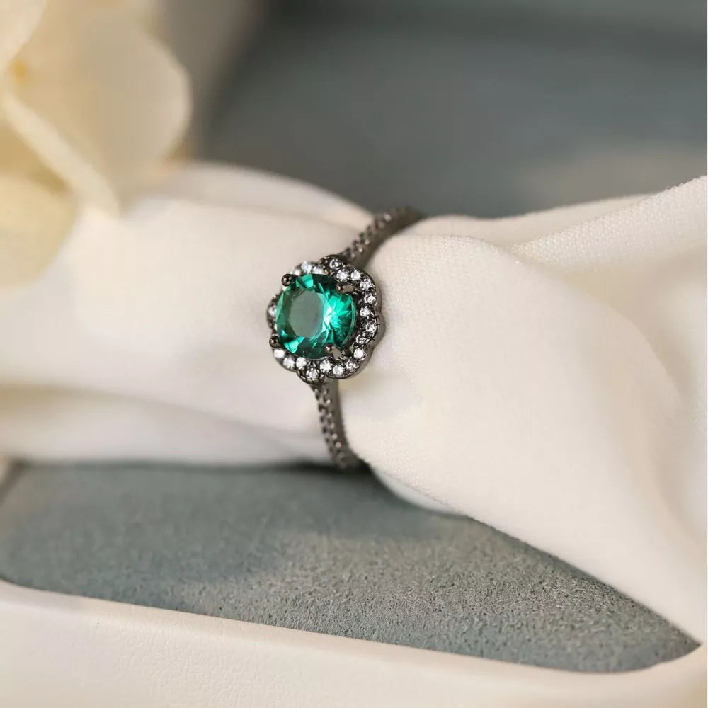 Elegant sterling silver ring with a green zircon and diamond halo.