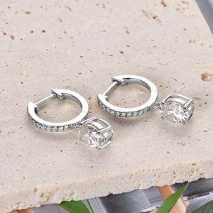 Silver pavé hoop and oval moissanite drop earrings with clear stones.