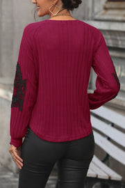 Deep red ribbed knit sweater with black lace appliqué on sleeves.