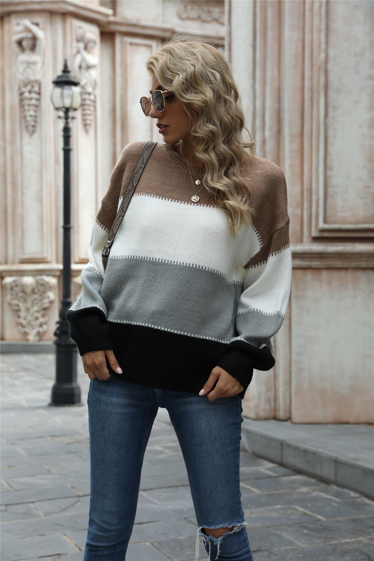 Crewneck knit sweater with horizontal color blocks in brown, white, gray, and black acrylic.