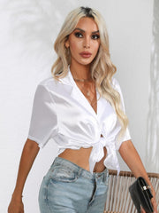 White satin tie-front collared shirt with short sleeves and button detail.