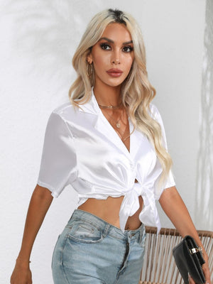White satin tie-front collared shirt with short sleeves and button detail.