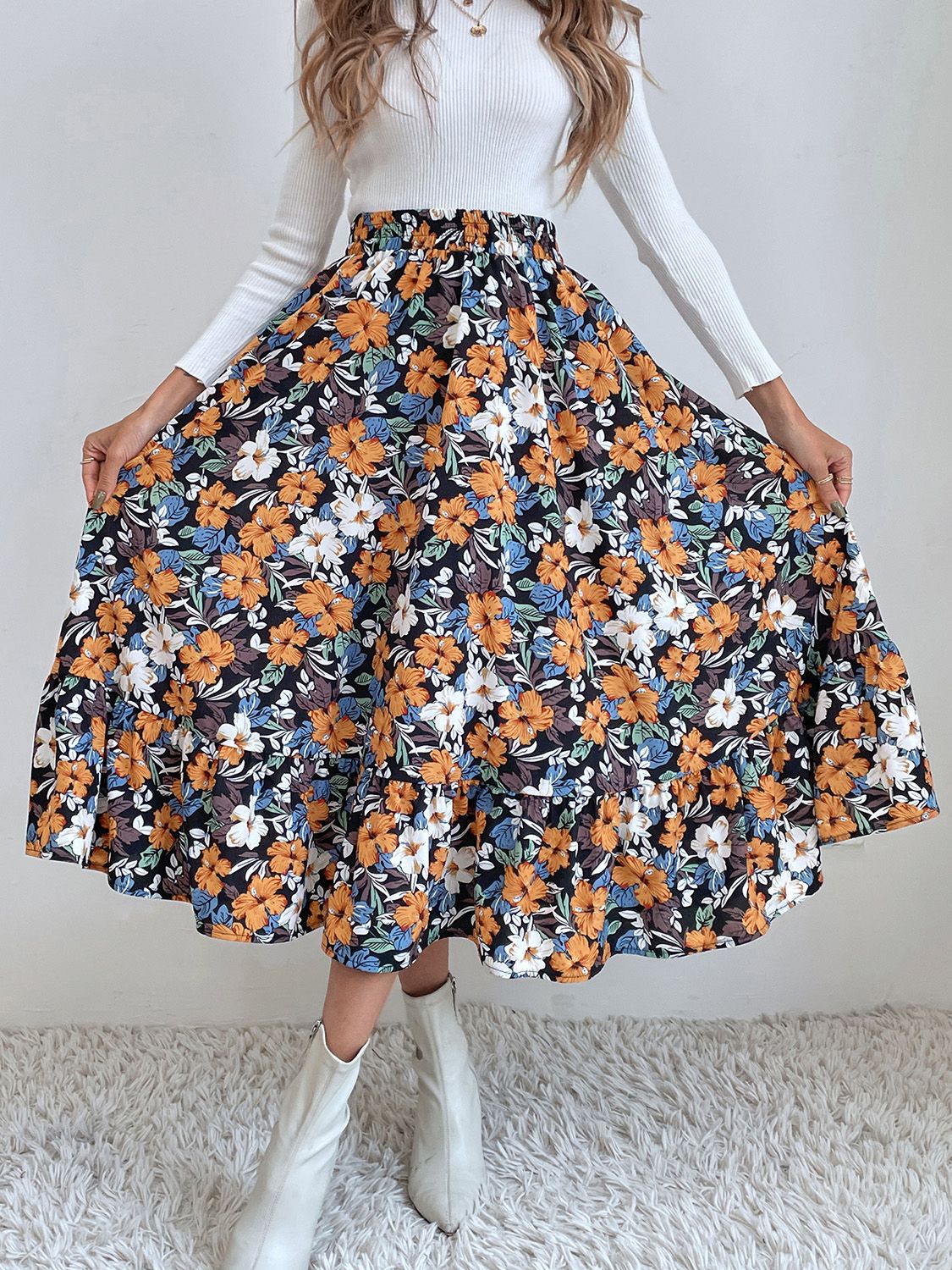 Tiered midi skirt with a black floral print, elastic waist, and ruffled hem.