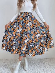 Tiered midi skirt with a black floral print, elastic waist, and ruffled hem.