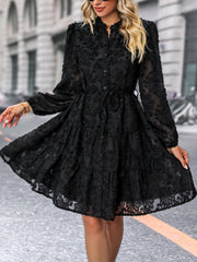Black textured puff sleeve tiered mini dress with button front and tie waist.