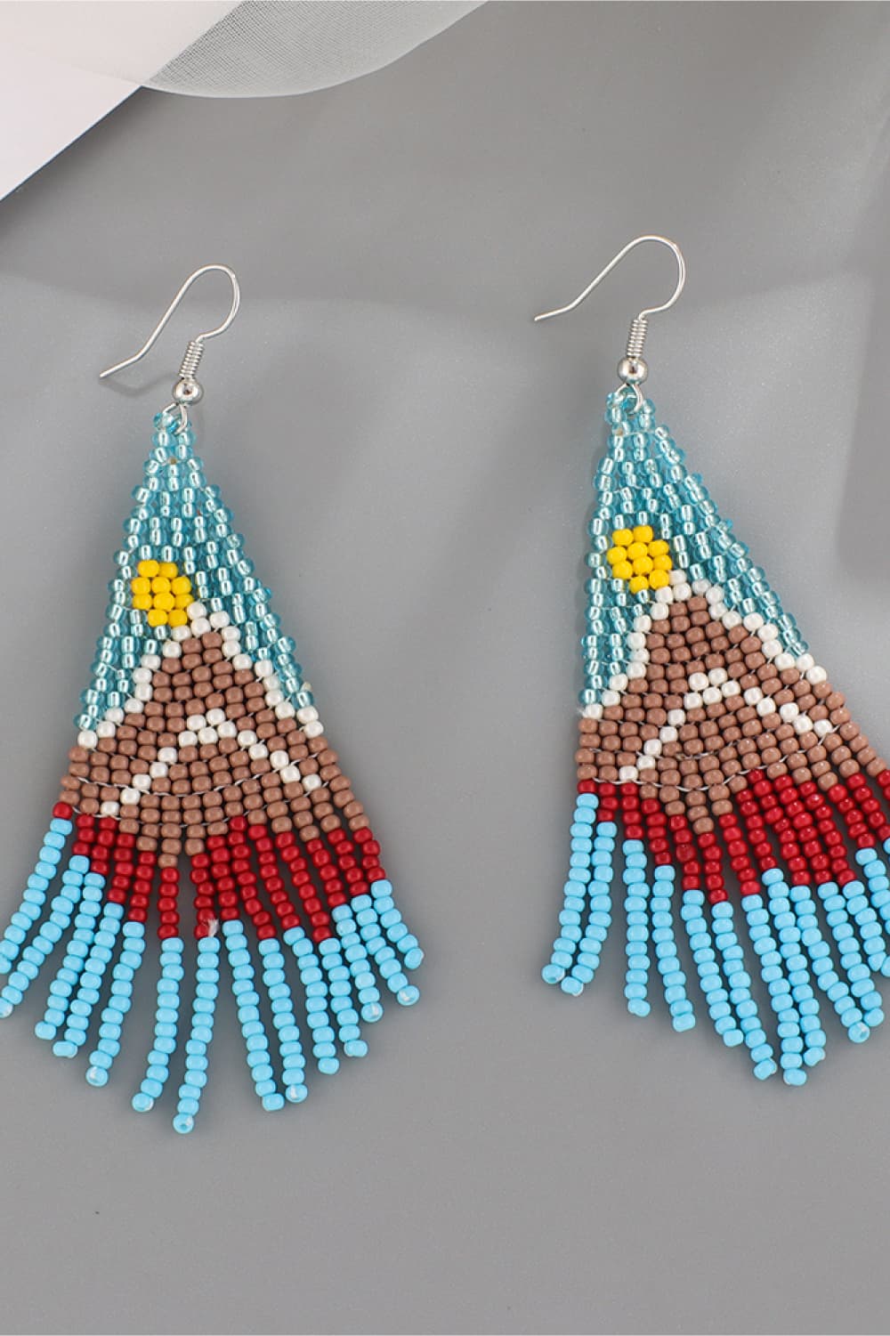 Chic beaded drop earrings in blue, brown, red, white, and yellow with a sun detail.