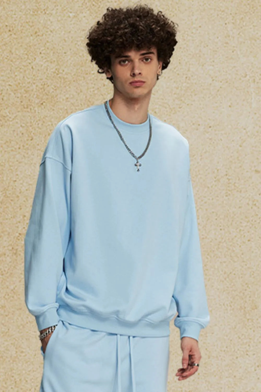 Light blue oversized crewneck sweatshirt with subtle shoulders and crew neckline.