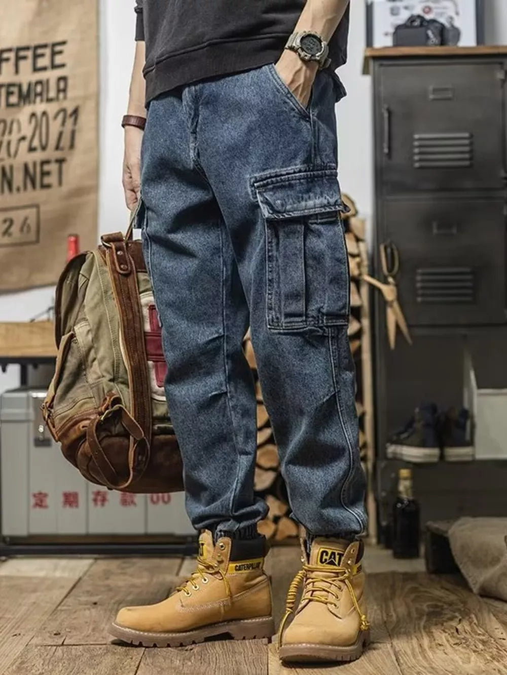 Men's vintage wash blue denim cargo jeans with multiple pockets and cuffed ankles.