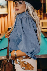 Denim maternity blouse with voluminous puff sleeves and collared neckline.