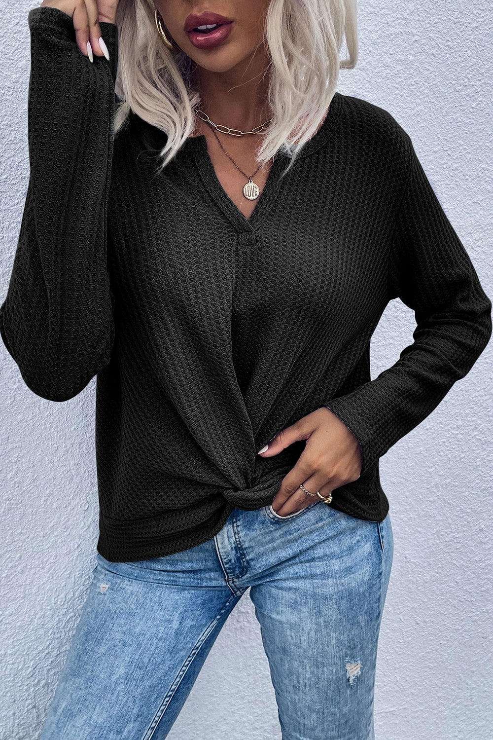 Black waffle knit top with knot front detail and V-neck.