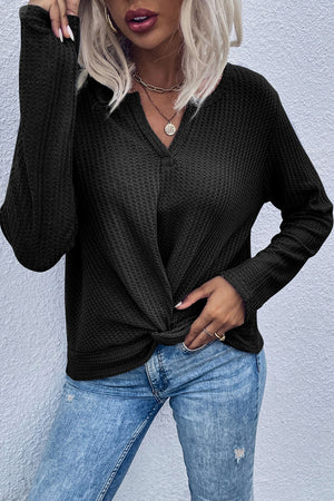 Black waffle knit top with knot front detail and V-neck.