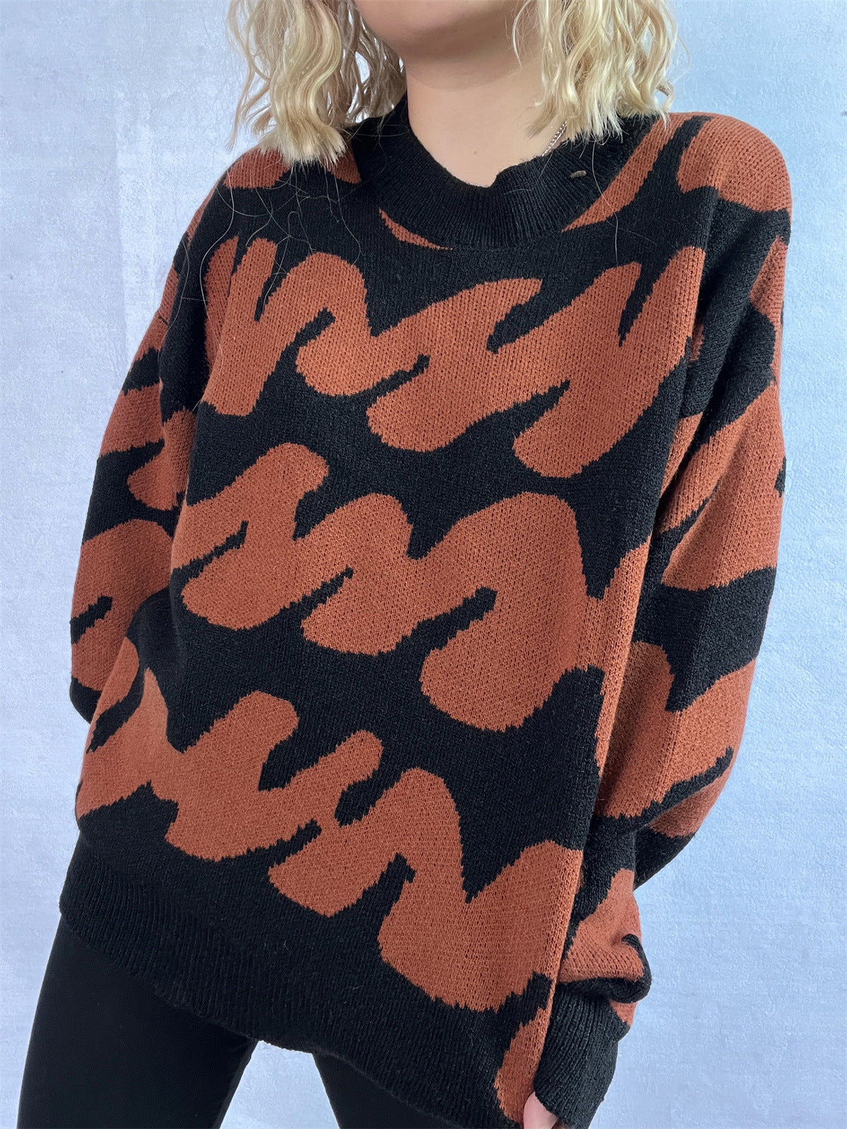 Graphic wave knit sweater in dark brown and black with a crew neck.