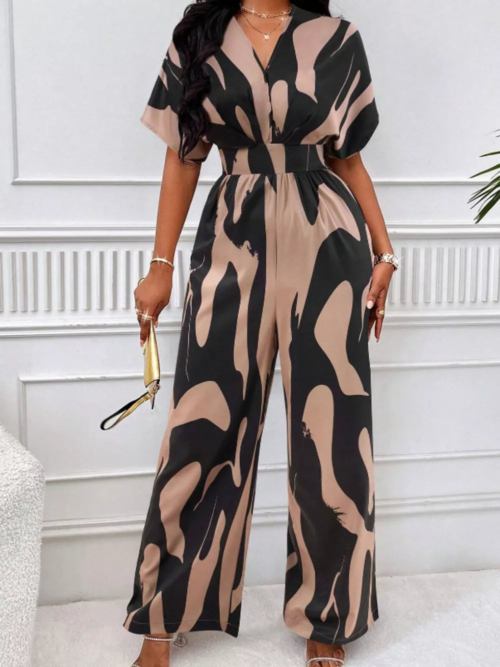 Chic abstract print wide-leg romper in black and khaki with short sleeves and V-neck.