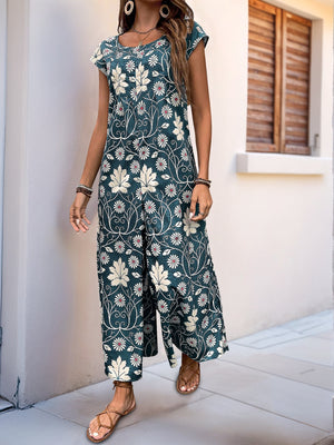 Botanical print culotte jumpsuit in dark green with short sleeves and a scoop neck.