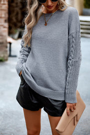 Light gray acrylic sweater with cable-knit sleeves and relaxed fit.