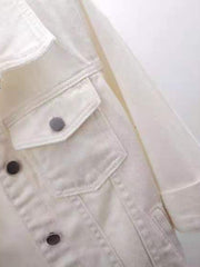 White denim trucker jacket with button-flap chest pockets and button front detail.