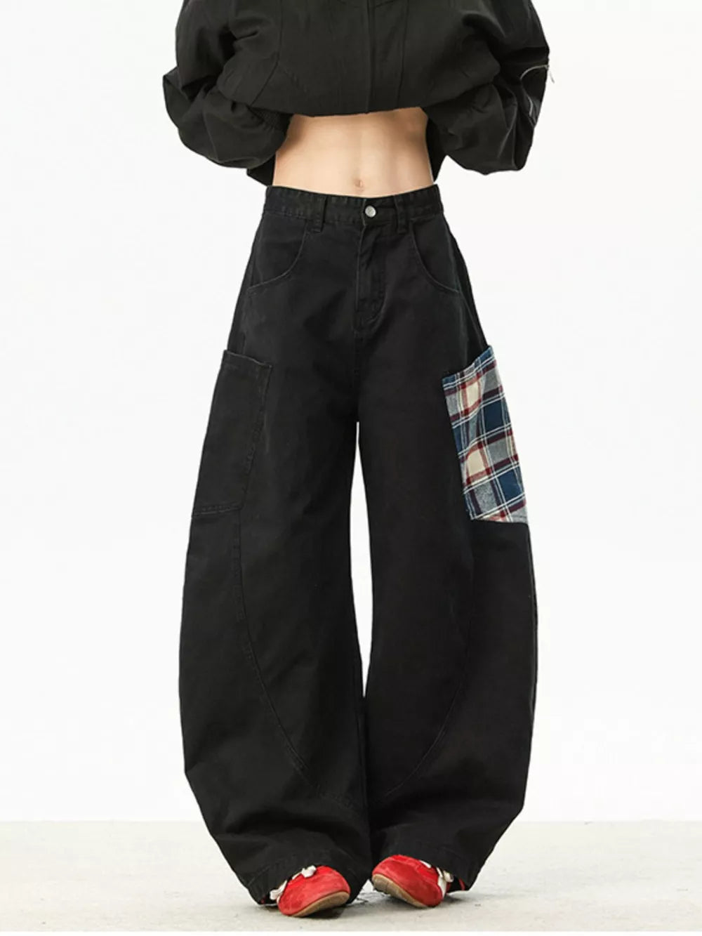 Black wide-leg sweatpants with plaid patchwork detail on the right hip.