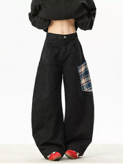 Black wide-leg sweatpants with plaid patchwork detail on the right hip.