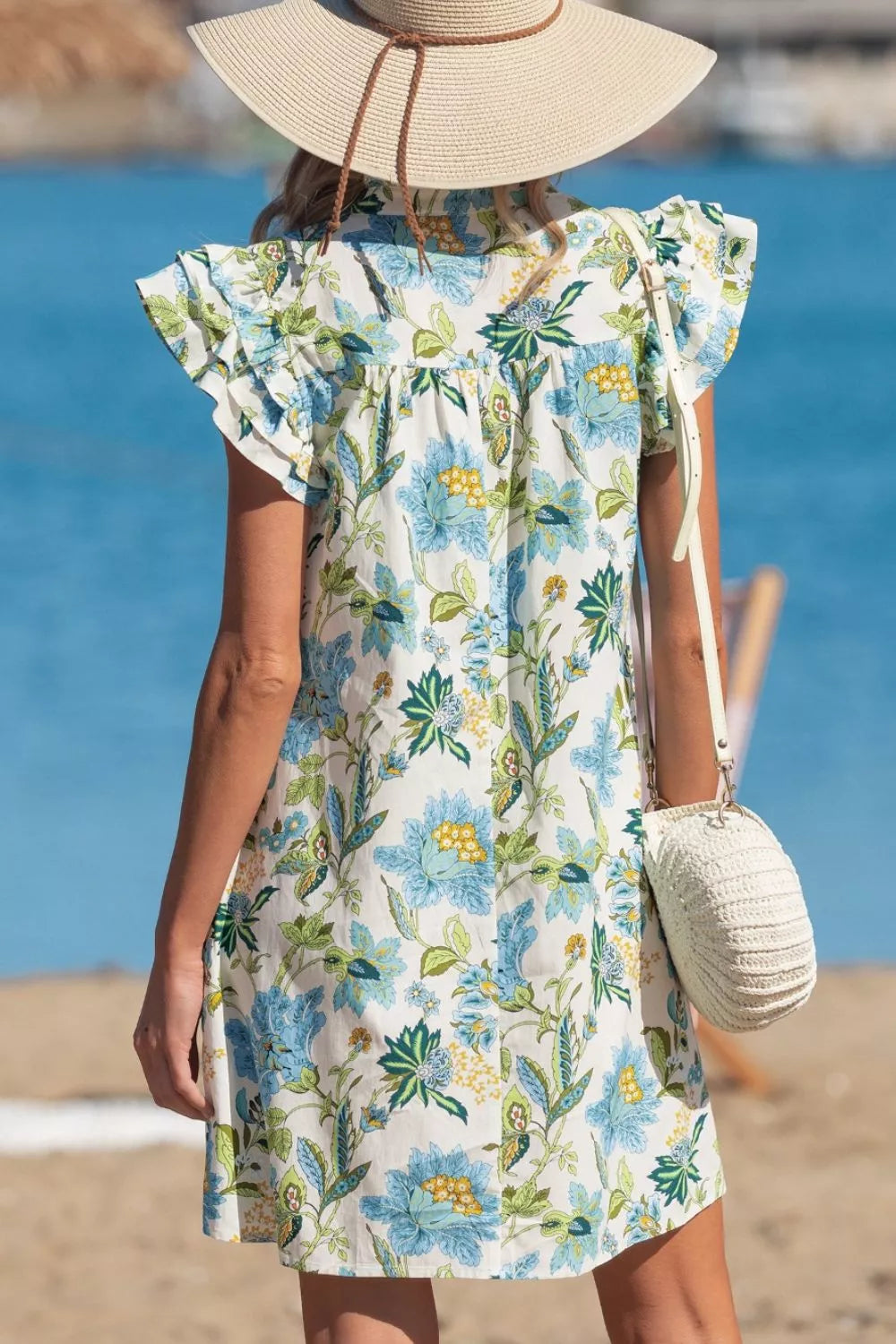 Floral V-neck mini dress with ruffled sleeves and a colorful print, made of cotton.