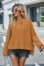 Caramel acrylic knit sweater with flared sleeves and slit hem detail.