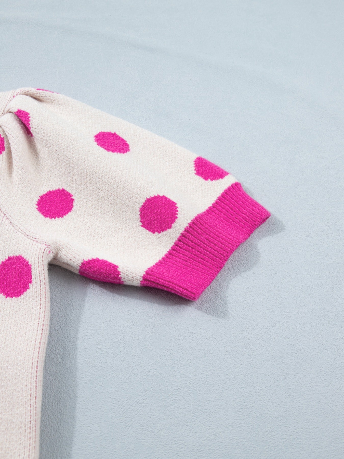 Cream polka dot knit top with hot pink dots and ribbed cuffs.