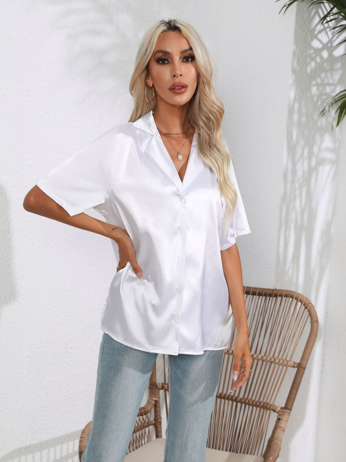 White satin collared shirt with short sleeves and button front, styled with jeans.