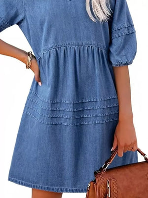 Light blue denim mini dress with puff sleeves, tiered skirt, and smocked waist.