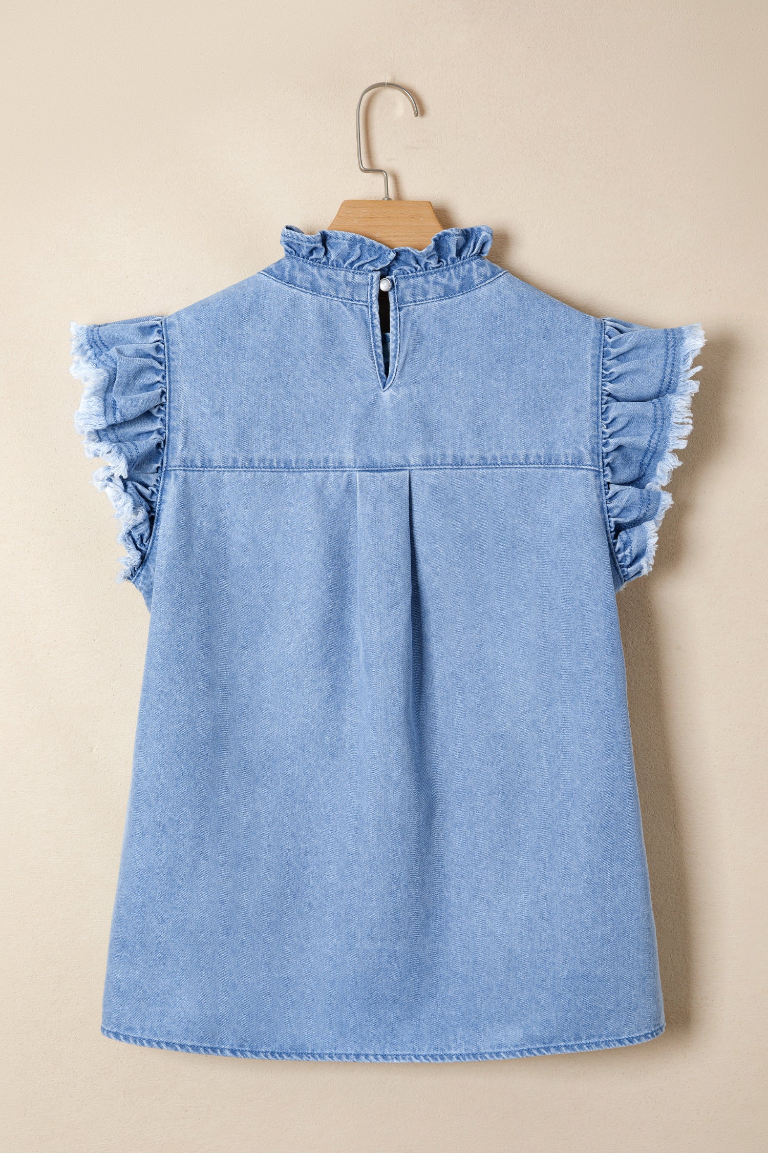 Light blue distressed denim top with frilled collar and ruffled cap sleeves.
