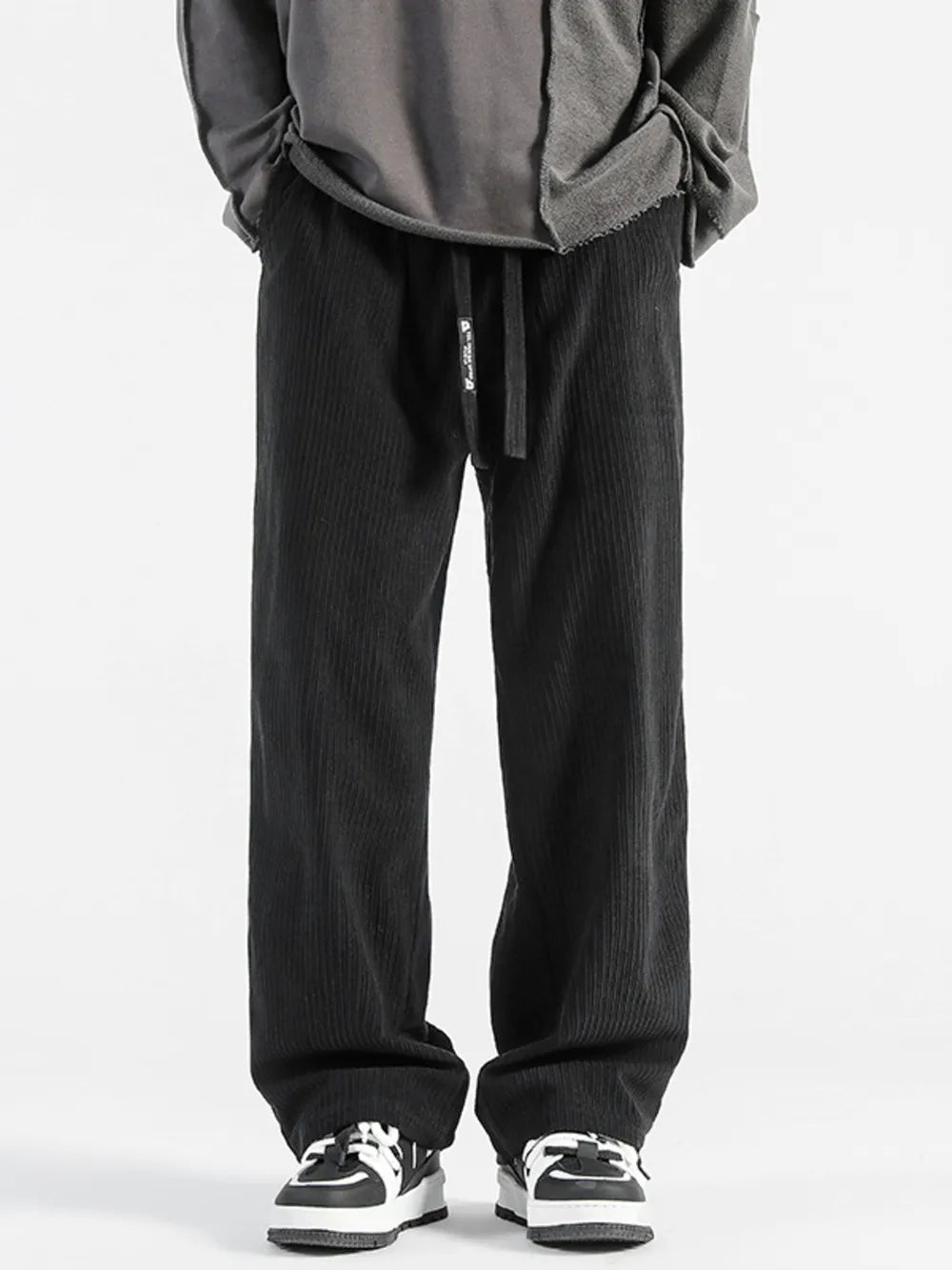 Black corduroy wide-leg sweatpants with drawstring waist and vertical ribbing.