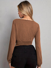 Textured wrap-front crop top in tan with long sleeves and a ribbed knit pattern.