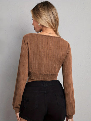 Textured wrap-front crop top in tan with long sleeves and a ribbed knit pattern.