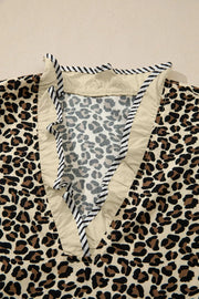 Leopard print mini dress with ruffle trim and striped neckline detail.