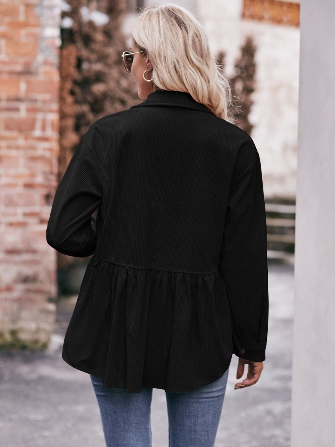 Black corduroy peplum shirt jacket with buttoned front and collared neckline.