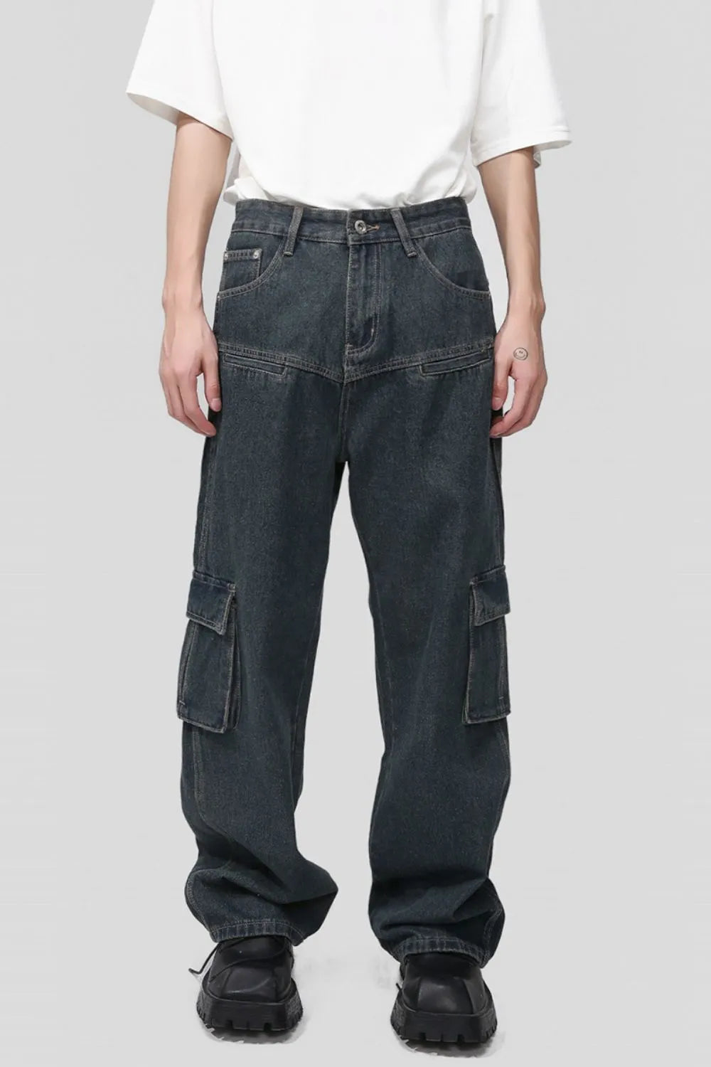 Panelled dark wash denim cargo pants with multiple pockets and a relaxed fit.