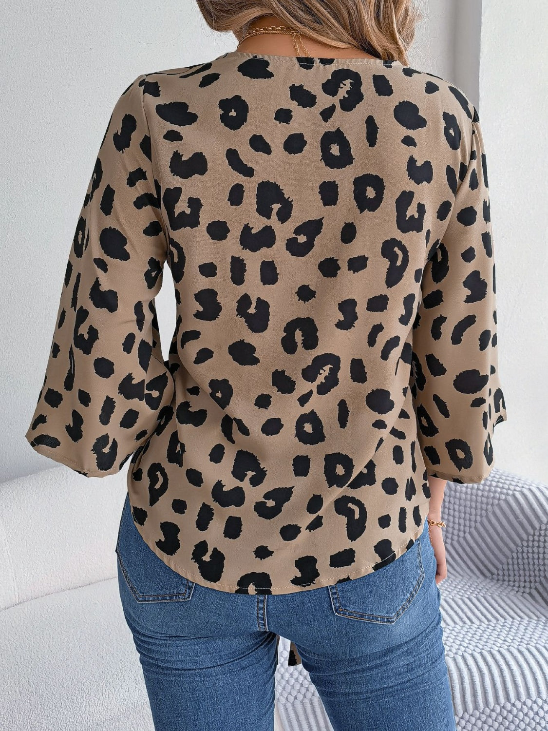 Khaki leopard print tie-front blouse with bell sleeves.