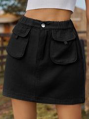 Black denim mini skirt with elastic waist and buttoned cargo pockets.