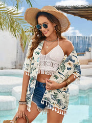 Pastel yellow tropical print kimono with tassel trim, worn open over a white crochet top and denim shorts.