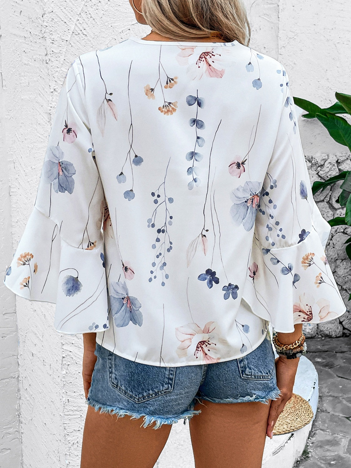 White floral bell sleeve blouse with delicate watercolor floral print and lace trim detail.