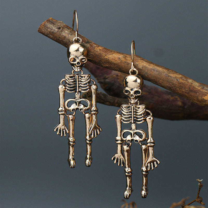 Gold skeleton silhouette drop earrings with intricate bone details.