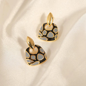 Geometric enamel drop earrings with black and grey abstract pattern and gold accents.